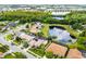 Aerial view displays a scenic pond behind several homes in a community, with landscaping and nearby roadway at 14634 Astina Way, Orlando, FL 32837