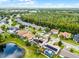 An aerial shot displays this home's solar panels, pool, landscaping, and proximity to a lake and a lush tree line at 14634 Astina Way, Orlando, FL 32837