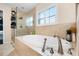 Elegant bathroom with a soaking tub, tiled surround, and frameless glass shower at 14634 Astina Way, Orlando, FL 32837
