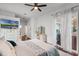 Bedroom with a ceiling fan, large TV, ensuite bath, and door to the covered patio at 14634 Astina Way, Orlando, FL 32837