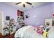 Bedroom featuring hardwood floors, purple walls, a bed, and a desk area at 14634 Astina Way, Orlando, FL 32837