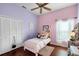 Charming bedroom with pink and purple walls, hardwood floors, a ceiling fan, and a window at 14634 Astina Way, Orlando, FL 32837