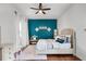 Bedroom featuring a turquoise accent wall, hardwood floors, and white curtains at 14634 Astina Way, Orlando, FL 32837