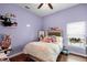 Bedroom featuring hardwood floors, purple walls, a bed, and a window at 14634 Astina Way, Orlando, FL 32837