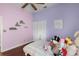 Bright bedroom with pink and purple walls, hardwood floors, and closet with paneled doors at 14634 Astina Way, Orlando, FL 32837