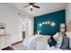 Bedroom with a ceiling fan, hardwood floors, and a turquoise accent wall at 14634 Astina Way, Orlando, FL 32837