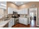 Open kitchen with white cabinets, stainless steel appliances, and hardwood floors at 14634 Astina Way, Orlando, FL 32837