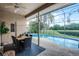Patio area with outdoor dining and screened pool overlooking a pond at 14634 Astina Way, Orlando, FL 32837