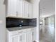 Elegant bar area with granite countertop, dark backsplash, and white cabinets offers a stylish entertaining space at 1556 Alligator St, St Cloud, FL 34771
