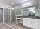 Spacious bathroom with granite vanity, large mirror, and a glass shower enclosure at 1556 Alligator St, St Cloud, FL 34771