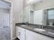 Double vanity bathroom with granite countertops and large mirror at 1556 Alligator St, St Cloud, FL 34771