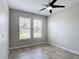 Empty bedroom featuring tile floors, two bright windows, and a ceiling fan at 1556 Alligator St, St Cloud, FL 34771