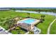 Aerial view of a community pool with lounge chairs, palm trees, and nearby playground at 1556 Alligator St, St Cloud, FL 34771