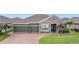Charming single-story home featuring a three-car garage, brick paved driveway, and well-manicured lawn at 1556 Alligator St, St Cloud, FL 34771