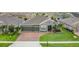 Charming single-story home featuring a three-car garage, brick paved driveway, and well-manicured lawn at 1556 Alligator St, St Cloud, FL 34771