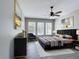 Comfortable main bedroom featuring a ceiling fan, art, and three bright windows at 1556 Alligator St, St Cloud, FL 34771