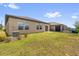 Back exterior of home showing windows, sliding glass door, and fenced yard at 1797 Sundance Chase Rd, Minneola, FL 34715