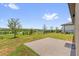 View of the backyard with a concrete patio, green grass, and a black metal fence at 1797 Sundance Chase Rd, Minneola, FL 34715