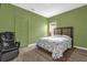 Green bedroom featuring wood floors, a chair, and a bed at 1797 Sundance Chase Rd, Minneola, FL 34715