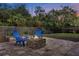 Backyard features a paved patio with an outdoor fireplace and cozy blue Adirondack chairs at 1945 Bering Ave, Winter Park, FL 32789