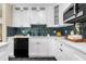 Modern kitchen with white cabinets, sleek backsplash, black appliances, and elegant countertops at 1945 Bering Ave, Winter Park, FL 32789