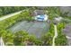 Aerial view of the community tennis courts with palm trees, pool, and clubhouse at 1950 Summer Club Dr # 200, Oviedo, FL 32765