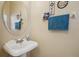 Cozy powder room with pedestal sink, round mirror, and decorative wall accents at 1967 Beacon Bay Ct, Apopka, FL 32712