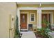 Inviting entryway with a decorative glass front door, charming plants and a cozy chair at 1967 Beacon Bay Ct, Apopka, FL 32712