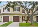 Charming townhome with a well-manicured lawn, brown shutters and a two-car garage at 1967 Beacon Bay Ct, Apopka, FL 32712