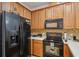 Well-equipped kitchen featuring stainless steel appliances, brown cabinetry and white countertops at 1967 Beacon Bay Ct, Apopka, FL 32712