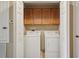 Convenient laundry area with washer, dryer, and storage cabinets, neatly tucked behind closet doors at 1967 Beacon Bay Ct, Apopka, FL 32712
