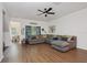 Bright living room featuring a comfortable gray sectional sofa, wood floors, and a ceiling fan at 1967 Beacon Bay Ct, Apopka, FL 32712