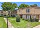 Inviting townhome with manicured lawn, mature trees, and brick and siding exterior at 200 St Andrews Blvd # 911, Winter Park, FL 32792