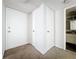 Bright hallway leading to a bathroom and featuring extra storage cabinets in a neutral color palette at 200 St Andrews Blvd # 911, Winter Park, FL 32792