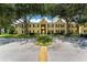 Building exterior featuring lush green trees, grass area, an entrance with a ramp, and ample parking at 2041 Dixie Belle Dr # 2041C, Orlando, FL 32812