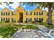 Inviting condo featuring a yellow facade, black shutters, and mature trees at 2041 Dixie Belle Dr # 2041C, Orlando, FL 32812