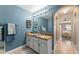 Bathroom with blue accent wall, granite countertop, and dual sink at 2042 Hayfield Way, Apopka, FL 32712