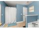 Bathroom featuring a shower, a door, and blue walls at 2042 Hayfield Way, Apopka, FL 32712