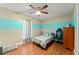 Cozy bedroom with a ceiling fan, hardwood floors, and stylish two-tone wall paint at 2042 Hayfield Way, Apopka, FL 32712