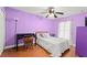 Bright bedroom with hardwood floors, ceiling fan, and a cozy bed with decorative pillows at 2042 Hayfield Way, Apopka, FL 32712