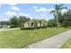 Well-maintained home features lush landscaping, blue shutters, and a spacious front lawn at 2042 Hayfield Way, Apopka, FL 32712