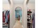 Hallway with arched doorways and tile flooring leading to a blue-walled bathroom at 2042 Hayfield Way, Apopka, FL 32712