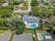 Aerial view of the property with a pool, surrounded by lush trees and neighborhood homes at 2220 Derbyshire Rd, Maitland, FL 32751