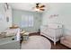 Light and airy Bedroom with white crib, modern ceiling fan and plantation shutters at 2220 Derbyshire Rd, Maitland, FL 32751