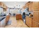 Well-lit kitchen featuring wooden cabinets, granite countertops, and stainless steel appliances at 2220 Derbyshire Rd, Maitland, FL 32751
