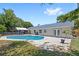 Backyard view of a refreshing pool with a screened lanai and lush landscaping at 2220 Derbyshire Rd, Maitland, FL 32751