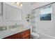 Updated bathroom with a cherry wood vanity, marble countertop, and a shower/tub combo with curtain at 245 Meadow Bay Ct, Lake Mary, FL 32746