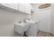 Well-lit laundry room with white cabinets, utility sink, washing machine, and a welcoming sign at 245 Meadow Bay Ct, Lake Mary, FL 32746