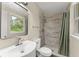 Bathroom with tiled shower, modern vanity, mirror and toilet with tiled floor at 247 Toms Rd, Debary, FL 32713