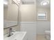 Bright bathroom featuring a large mirror, modern vanity and toilet and beadboard at 247 Toms Rd, Debary, FL 32713